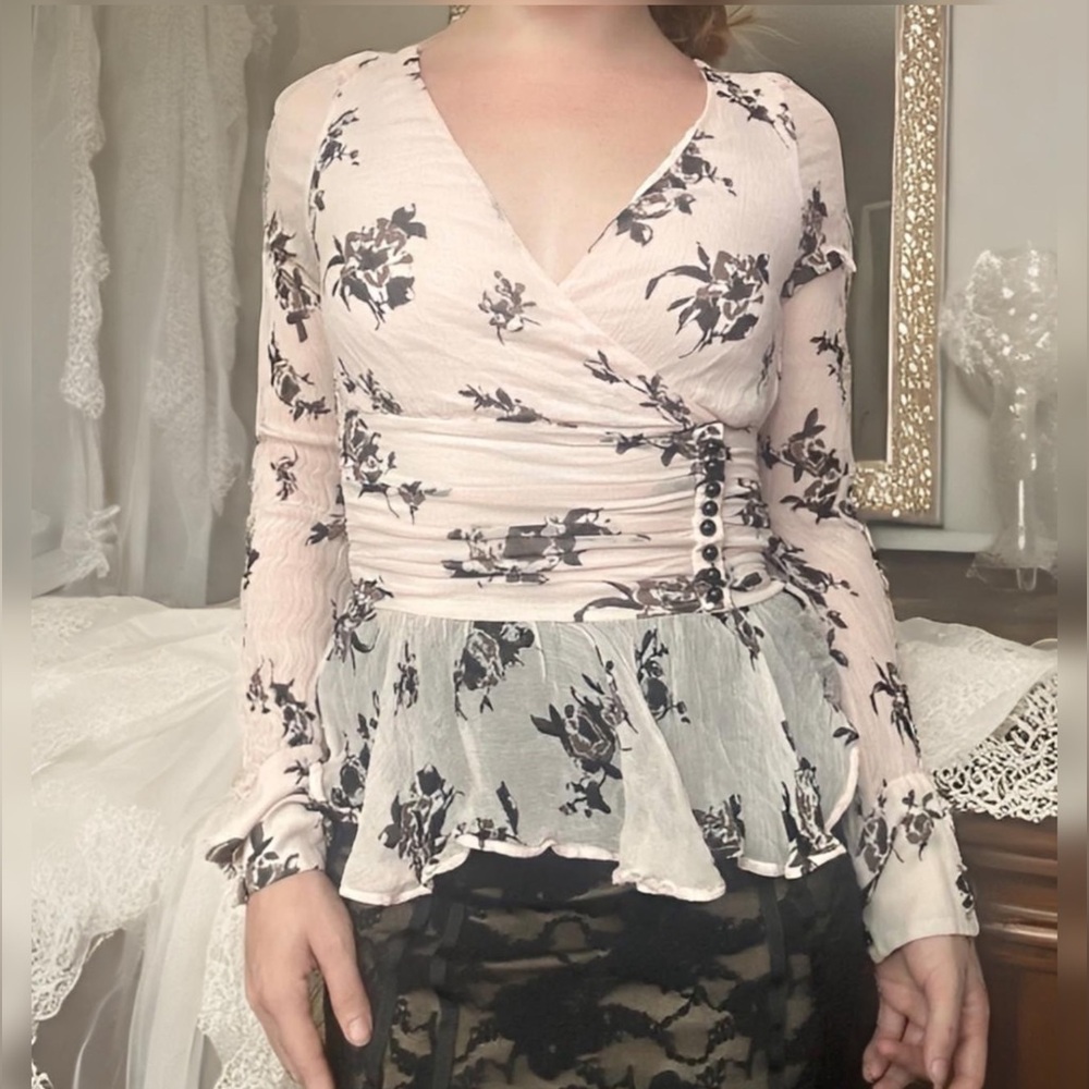 A very pale pink floral top with sheer sleeve and back